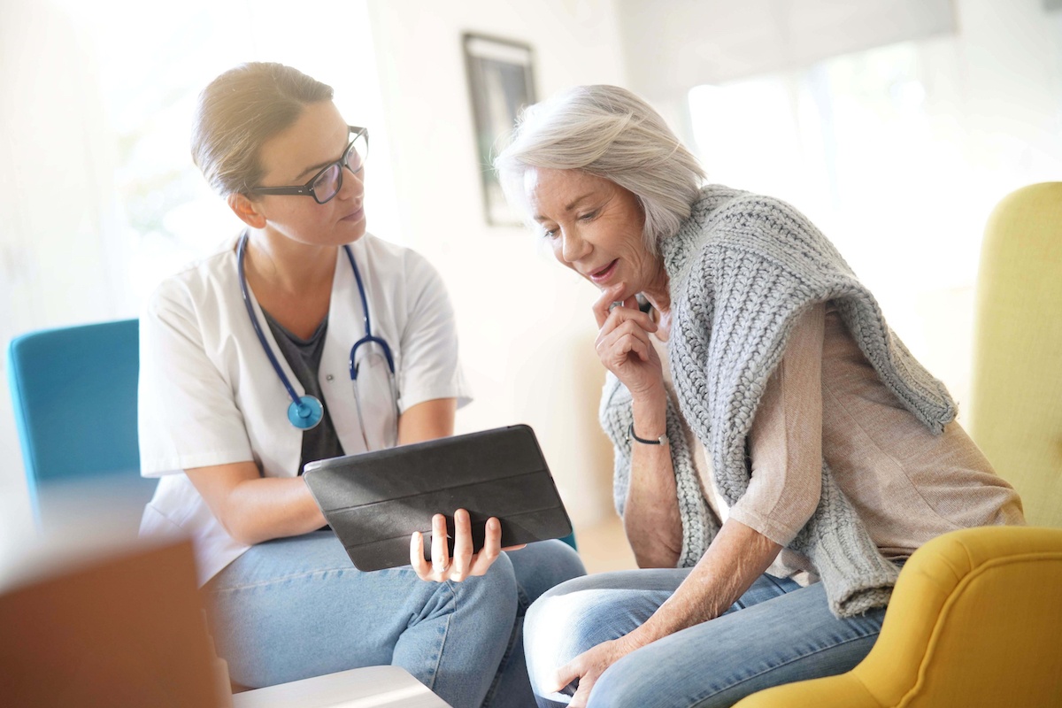 An older female patient asking a female doctor questions about hip replacement surgery