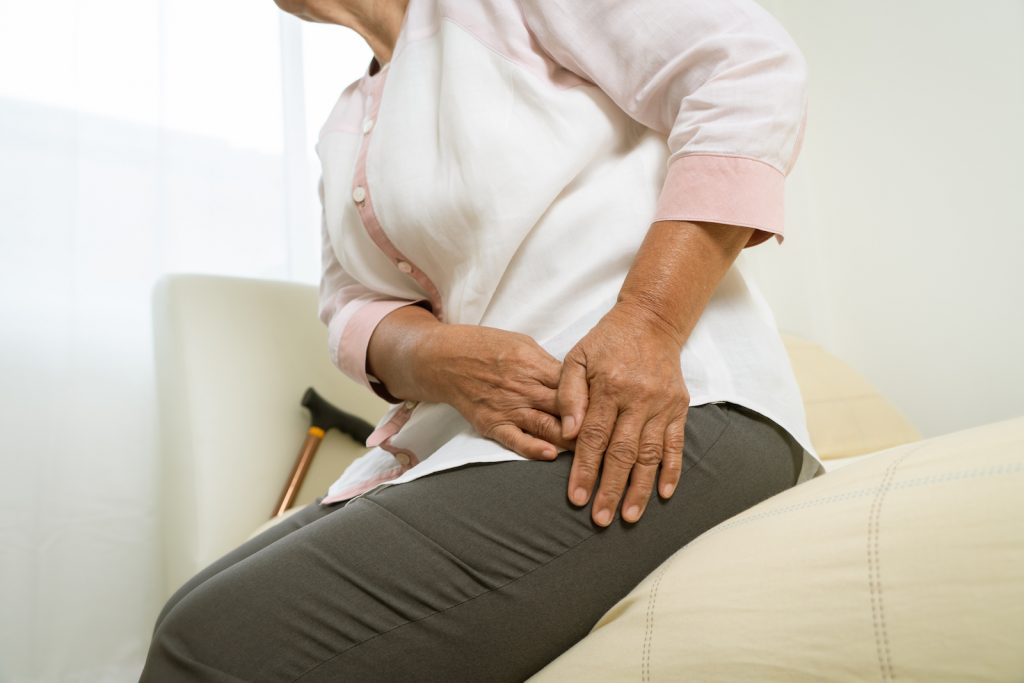 An older woman showing a sign of hip pain.