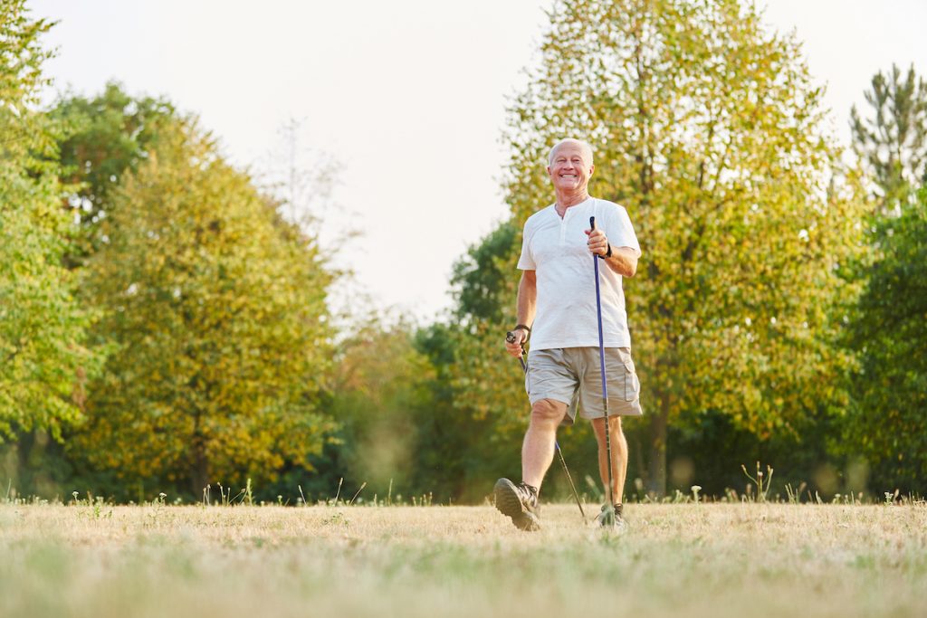 An older man walking after hip replacement surgery.