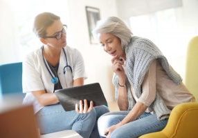 An older female patient asking a female doctor questions about hip replacement surgery