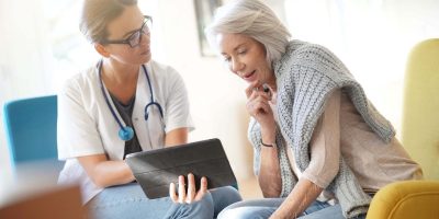 An older female patient asking a female doctor questions about hip replacement surgery