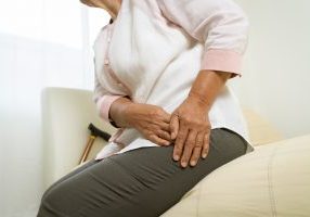 An older woman showing a sign of hip pain.