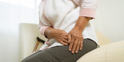 An older woman showing a sign of hip pain.